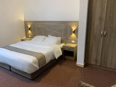 a bedroom with a large bed and two night stands at Asad Apt. in Wadi Musa