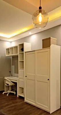 a room with a white desk and a refrigerator at Elite Corner Apartment in Ţāb Kirā‘