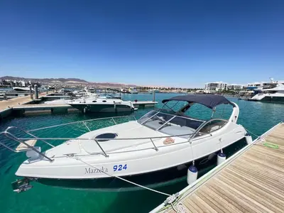 a white boat docked at a dock in the water at Roza Beach Aqaba in Aqaba