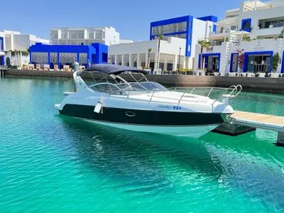 a boat is docked at a dock in the water at Roza Beach Aqaba in Aqaba
