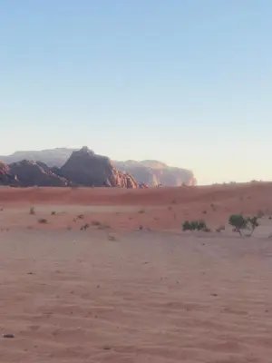 a view of a desert with mountains in the background at Wadi Rum White Mountain Camp in Wadi Rum