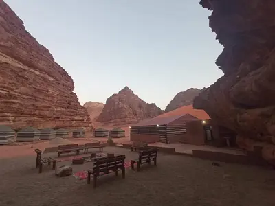 a group of benches in front of some mountains at Wadi Rum White Mountain Camp in Wadi Rum