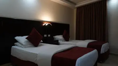 a hotel room with two beds with red and white pillows at petra agora hotel in Wadi Musa