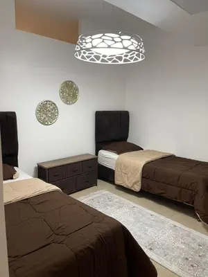 a bedroom with two beds and a chandelier at Romantic chalet between swimming pools and close to the seashore for families only in Aqaba
