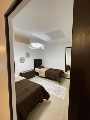 a bedroom with two beds and a mirror at Romantic chalet between swimming pools and close to the seashore for families only in Aqaba