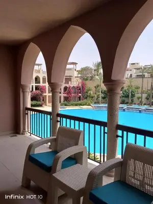 a balcony with two chairs and a swimming pool at Romantic chalet between swimming pools and close to the seashore for families only in Aqaba