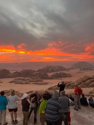 a group of people watching the sunset in the desert at Bedouins nights in Wadi Rum