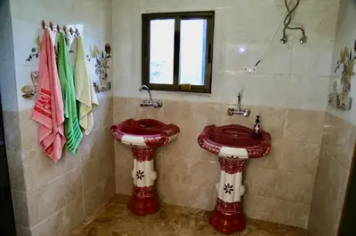 a bathroom with a red sink and a window at private room with cultural experience and great landscapes in Şirfah