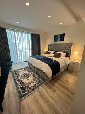 a bedroom with a large bed and a large window at Luxury Apartment in DAMAC Towers in Amman