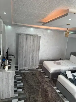 a bedroom with two beds and a tv in it at Petra Pillars Way Hostel in Wadi Musa