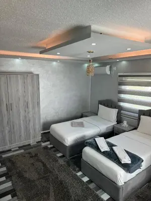 a bedroom with two beds and a chandelier at Petra Pillars Way Hostel in Wadi Musa