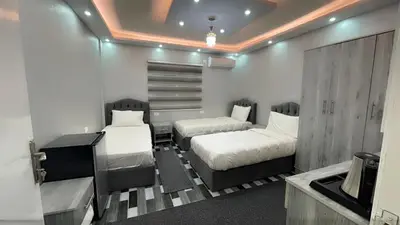 a bedroom with two beds and a television in it at Petra Pillars Way Hostel in Wadi Musa