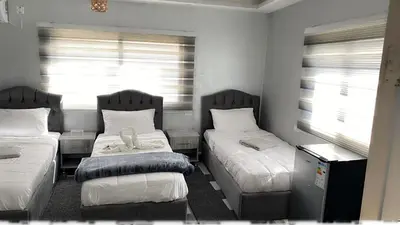a small bedroom with two beds and a window at Petra Pillars Way Hostel in Wadi Musa
