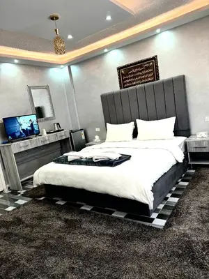 a bedroom with a large bed and a flat screen tv at Petra Pillars Way Hostel in Wadi Musa