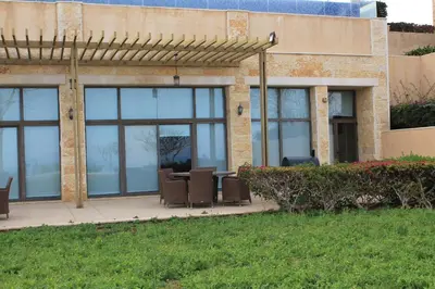 a patio with a table and chairs in front of a building at Samarah Dead Sea Resort Studio-CP6 Traveler Award 2026 Winner Thursday, Friday and Saturday Groups consisting solely of male guests are not permitted in Sowayma