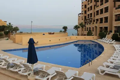 a swimming pool with lounge chairs and an umbrella at Samarah Dead Sea Resort Studio-CP6 Traveler Award 2026 Winner Thursday, Friday and Saturday Groups consisting solely of male guests are not permitted in Sowayma