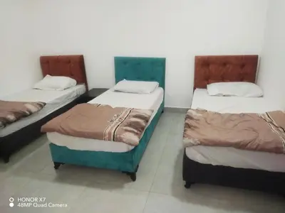a room with three beds in a room at Farah Plaza Hostel &Hotel Apartments in Aqaba