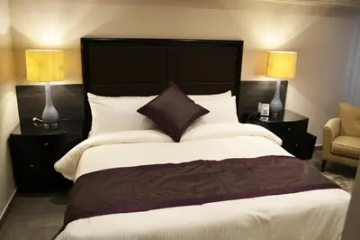 a bedroom with a large bed with a black headboard at Ambassador, a Boutique Hotel in Amman