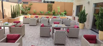 an outdoor patio with tables and chairs and sidx sidx sidx at Black Iris Hotel II in Madaba