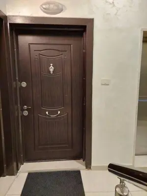 a brown door in a room with a black rug at Exquisite Modern 2-bedroom Rental Unit in Amman