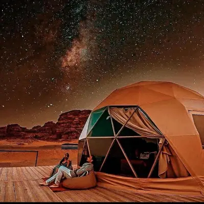 two people sitting in a tent under a starry sky at Mountain Magic Camp Wadi Rum in Wadi Rum