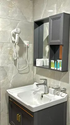 a bathroom with a sink and a hair dryer at Mountain Magic Camp Wadi Rum in Wadi Rum