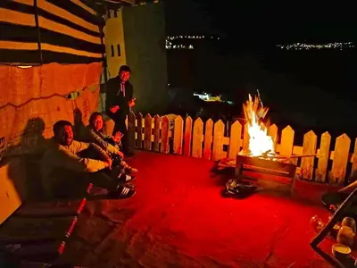 a group of people sitting around a fire at Petra NefNaf Hostel in Wadi Musa