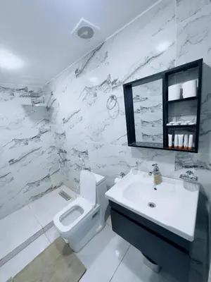 a white bathroom with a toilet and a sink at Rum Four Seasons luxury Camp & Jeep Tours in Wadi Rum