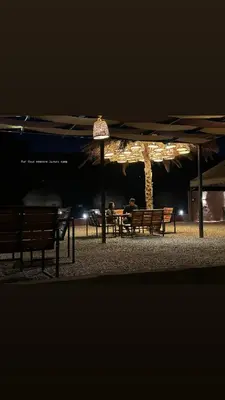 a group of benches under an umbrella at night at Rum Four Seasons luxury Camp & Jeep Tours in Wadi Rum
