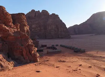 a group of benches in the desert near a mountain at Bedouin Memories Camp in Wadi Rum