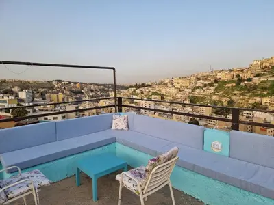a blue couch and chairs on top of a building at Rainbow Guest House in Amman