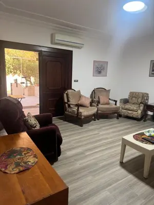 a living room with couches and chairs and a table at Abdoun ground floor apartment in Amman