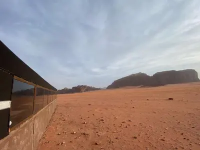 a view of the desert with mountains in the background at Wadi Rum Odyssey Camp in Wadi Rum