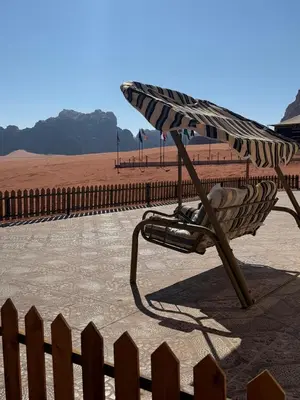 a hammock on a beach with a fence at falling Stars Camp in Wadi Rum