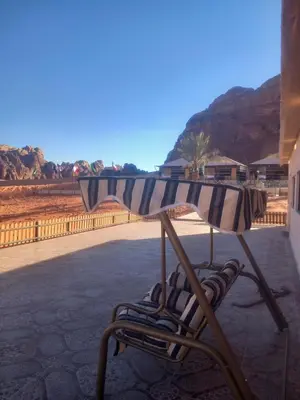 a beach umbrella and chairs on a patio at falling Stars Camp in Wadi Rum