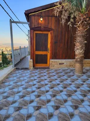 a house with a wooden door and a stone floor at atoom lodge in Jerash