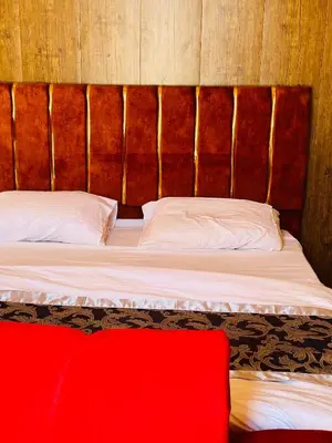 a bedroom with a bed with a wooden headboard at Sandy Camp Wadi Rum in Wadi Rum