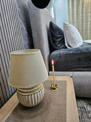 a lamp on a table next to a couch with a candle at Hadrian's Arch in Jerash