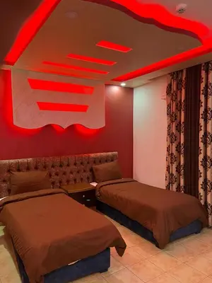a room with two beds and a red ceiling at Shihan hotel suites in Amman
