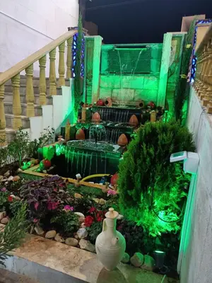 a garden with a staircase with green lights at Shihan hotel suites in Amman
