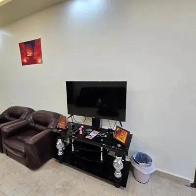 a living room with a leather couch and a flat screen tv at Authentic boutique in Wadi Musa
