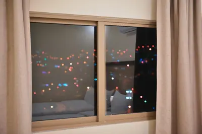 a window with a view of a christmas tree in the background at Beit Alshabaan Inn in Wadi Musa
