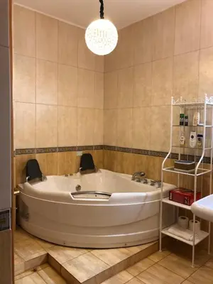 a bath tub in a bathroom with a chandelier at Charming House in Amman + Balcony in Amman
