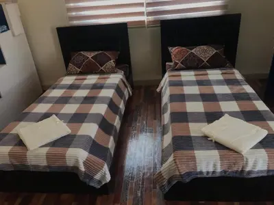 two beds sitting next to each other in a room at Safi Kitchen Hostel in Aş Şāfī