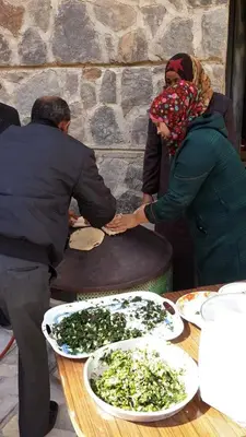 a group of people standing around a table with food at Safi Kitchen Hostel in Aş Şāfī