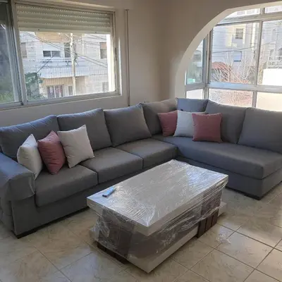 a living room with a couch and a coffee table at شقة مفروشة في ام اذينة in Amman