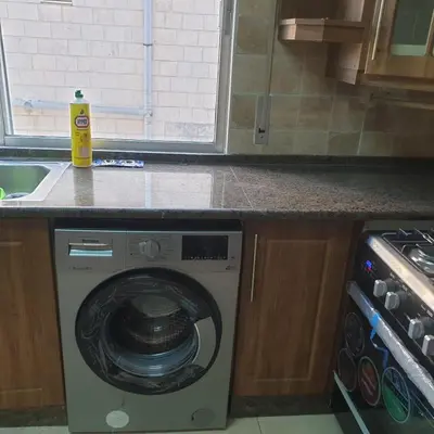 a washing machine in a kitchen next to a counter at شقة مفروشة في ام اذينة in Amman