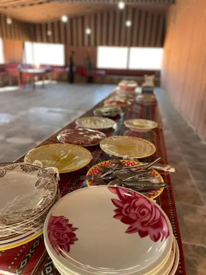 a long table filled with plates and bowls on it at Wadi Rum Magic Camp in Wadi Rum