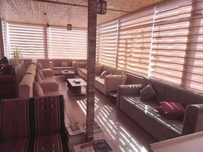 a large living room with couches and windows at Petra voyager Hostel in Wadi Musa