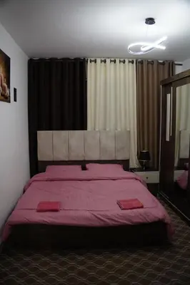 a bedroom with a large bed with a red blanket at Petra voyager Hostel in Wadi Musa